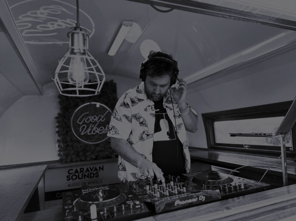 DJ holding headphones looking down